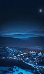 a nighttime view of a town with a bridge crossing the river