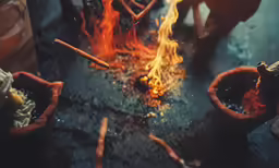 two red clay pots with burning hot coal on a table