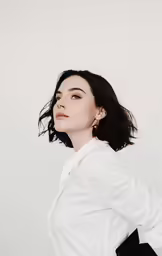the woman is standing against a wall posing for a photo