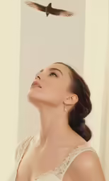 the woman is standing under an eagle on the wall