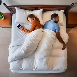 an adult couple in bed while a child lies beside them