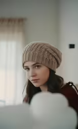 a woman with blue eyes wearing a brown hat