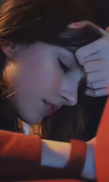 a young woman is sitting down holding her head and looking sad