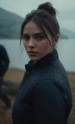 a woman is standing in front of the water