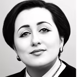 a black and white photo of a woman wearing pearls
