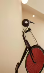 the bicycle is displayed in a white walled room