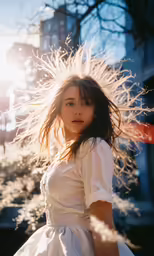 an attractive woman in a white dress posing