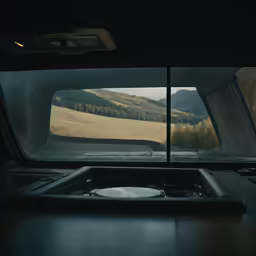 the view outside a truck window looking into the hills and trees