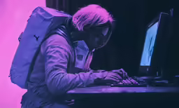 a person typing on their computer at a purple desk