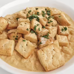 a white bowl filled with food sitting on top of a table