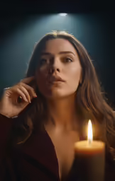 a woman standing in front of a lit candle with light on