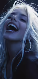 a woman with blonde hair singing into microphone