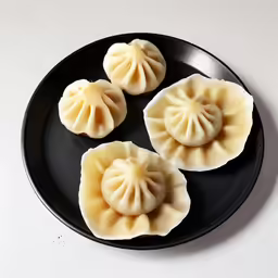 three small dumplings are displayed on a plate