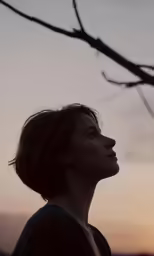 a person that is standing next to a tree