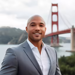 a man is smiling for the camera in front of a bridge