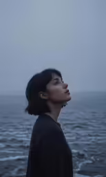 the girl stares at the water from behind