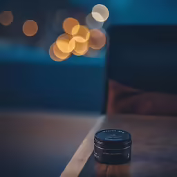 a small black container sitting on top of a wooden table