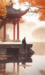 there is a man sitting on a wall near a pond