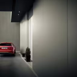 an automobile is parked between two cement buildings