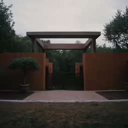 a gated yard next to some trees and bushes