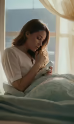 there is a woman sitting on a bed reading