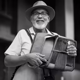 an old man is holding a basket and smiling