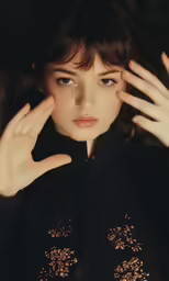 a woman wearing a black jacket poses for a picture