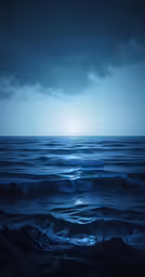 the blue ocean with waves and a light above