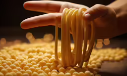 someone is reaching over a pile of spaghetti