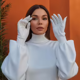 a woman wearing white is posing for a photo