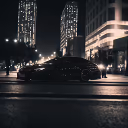 a black car parked in front of a high rise building