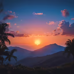the sun setting in the distance behind mountains with palm trees on either side