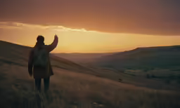 a woman standing in an open field with her hands up