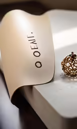 an open ring sits on a piece of paper next to it