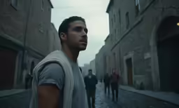 there is a man looking into the distance on the street