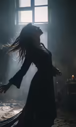 a woman in a dark room is reaching into the air