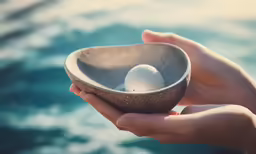 a bowl with two eggs in it that is held by someone