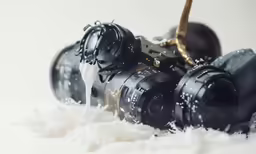 two cameras next to each other sitting on snow