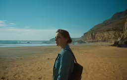 there is a woman walking along the beach