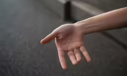 the hand of a person reaching to grab something