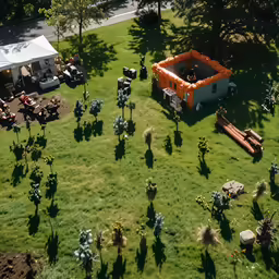 the aerial view of some tables and umbrellas in a yard