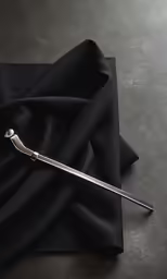 a long silver object sitting on top of a black cloth