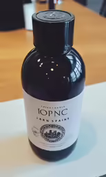 a bottle of black ink on a wooden table