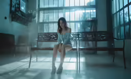 woman posing on wooden bench in building near large windows
