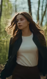 a woman standing outside in the woods with hair