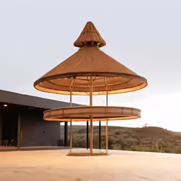 a structure with multiple round tables and umbrellas on top