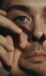 a man is touching his face with one hand