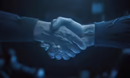 two people shaking hands in the dark