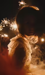 there is a woman looking at the firework in her hair
