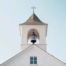 a church with an iron cross and steeple